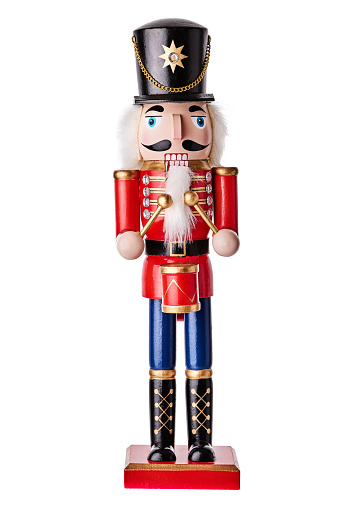 Traditional Christmas nutcracker wooden figure. Beautiful, festive toy soldier decoration, with Christmas tree lights bokeh in background.