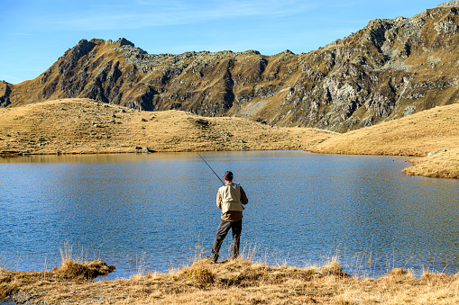 Fisherman fishing in a lake in the mountains