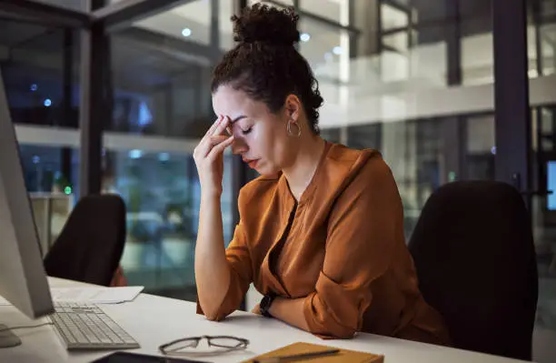 Woman working at night with headache, burnout and stress over social media marketing project or company deadline. Anxiety, exhausted and tired online advertising or web promotion expert with migraine