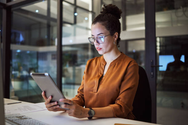 istock Woman working in Toronto office at night, big data analytics and reading expert research on digital tablet. Database administrator in dark, overtime work on company report and iot in tech business 1448283739