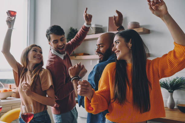 istock Beautiful young people dancing and smiling while enjoying home party together 1448284619