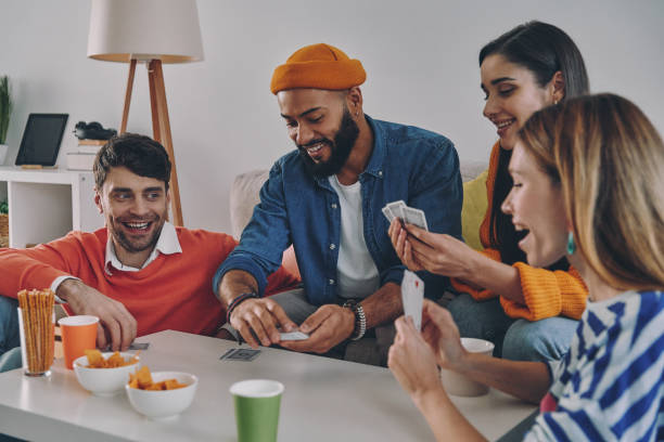 istock Cheerful young people playing cards while enjoying carefree time together 1448284655