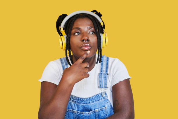 音楽を聴く物思いにふけるアフリカの女性 - braids african descent women pensive ストックフォトと画像