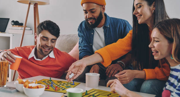 istock Beautiful young people playing board game while enjoying carefree time together 1448287743
