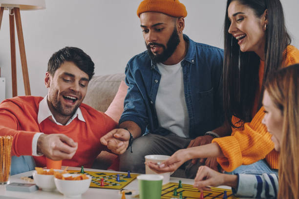 istock Happy young people playing board game while enjoying carefree time together 1448287745