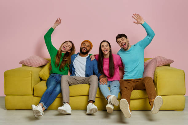 istock Studio shot of beautiful young people embracing and smiling while sitting on the couch together 1448288761