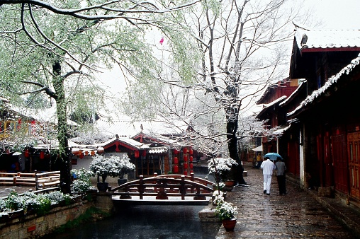 Although located at the foot of the Jade Dragon Snow Mountain, the old town of Lijiang is warm in winter and rarely snows. In some winters the snow falls, and then it melts completely within an hour or two. Therefore, the snow scenery of the Old Town is rare. Photographic slide photo in  Feb 23, 2005, Lijiang, Yunnan