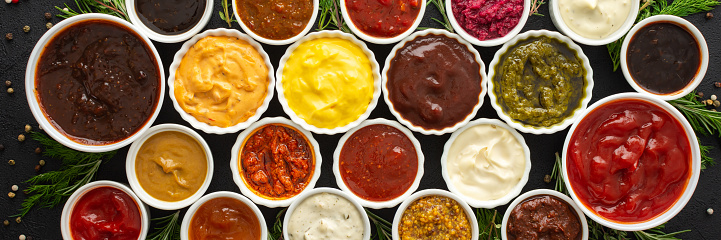 Different types of sauces in bowls with seasonings banner, rosemary and dill, thyme and and peppercorns, top view