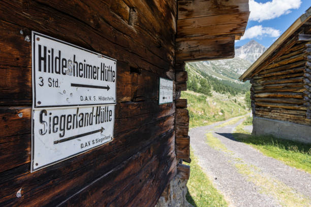 białe drogowskazy dojazdu do schronisk górskich w alpach ötztalskich przy drewnianej ścianie alpejskiej stodoły w dolinie windach, sölden, austria - oetztal alps zdjęcia i obrazy z banku zdjęć