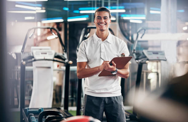 palestra, fitness e ritratto di un personal trainer con un blocco appunti per una consulenza di allenamento. felice, sorridente e allenatore sportivo o atleta con una lista di controllo per il benessere, la salute e l'esercizio fisico nel centro di allenam - coach foto e immagini stock