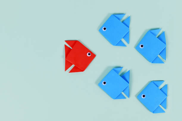 istock Paper fish swimming swimming against the current 1448292634