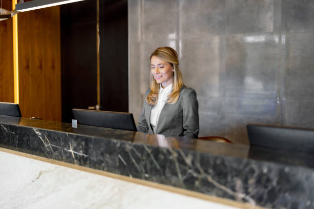 female receptionist working at hotel counter - airport check in counter imagens e fotografias de stock