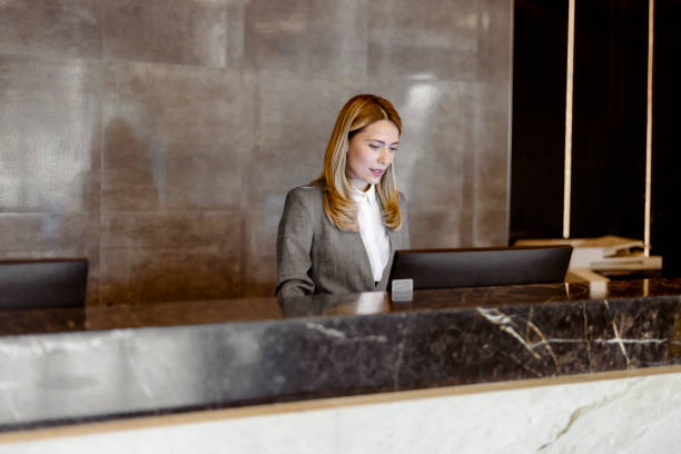 istock Female receptionist working at hotel counter 1448294393