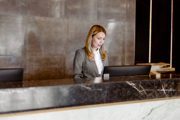 Female receptionist working at hotel counter stock photo
