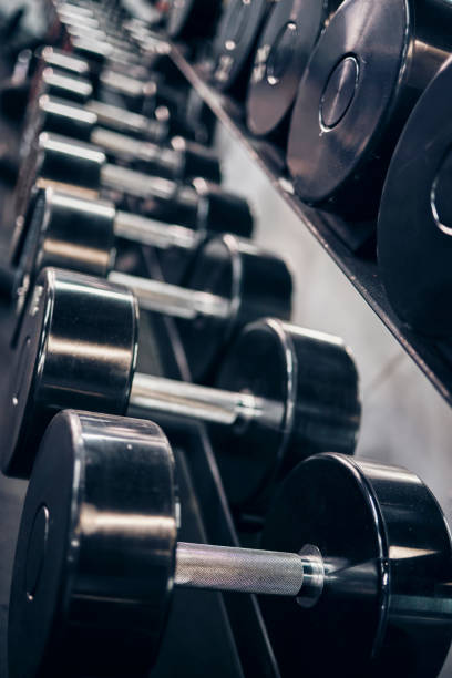 istock Fitness, workout and dumbbells in an empty gym for exercise, body building development or strength training for wellness. Commitment, motivation or heavy metal weights for strong arms or body muscles 1448295747