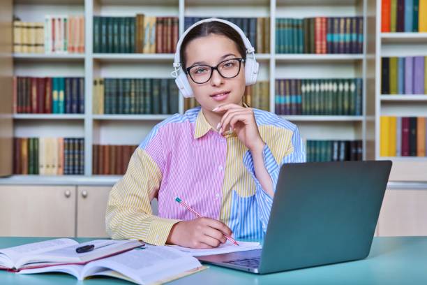 istock Teenage girl student studying in library, using laptop 1448297333