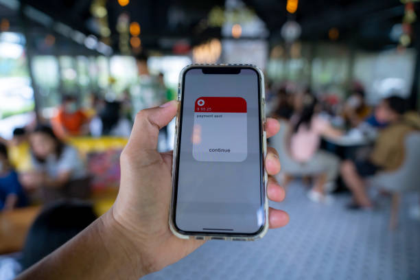 istock Hand holding mobile phone with application making payment cashless payment transaction. 1448297442