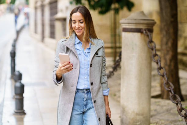 istock Woman reading messages on cellphone on street 1448297680