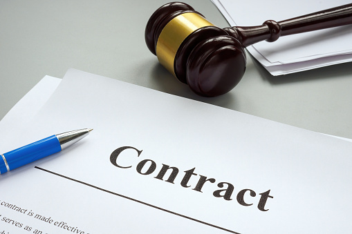 A Contract near gavel on the desk. Contract Disputes concept.