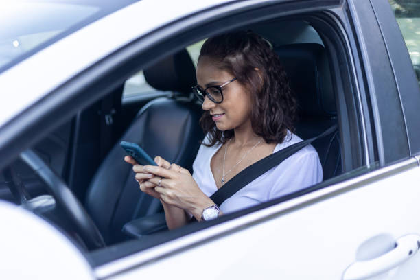istock Woman using cell phone inside electric car 1448303284