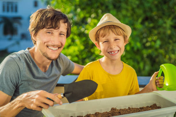 Dad and son is doing gardening on his balcony. Natural development for children