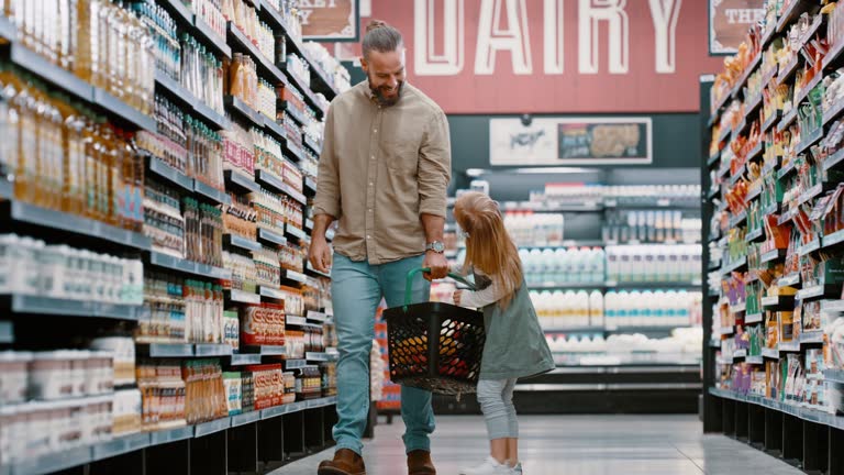 Man, child or girl in in family grocery store for retail cooking ingredients, healthy food product or groceries sales goods. Father, kid or walking in supermarket aisle with shopping container