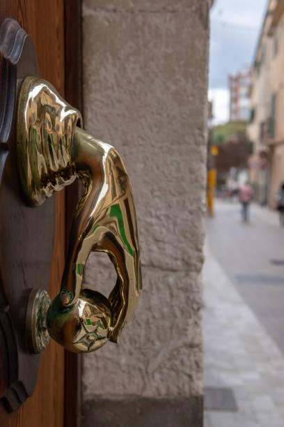 Gold-plated exterior door knob in the shape of a hand with an apple