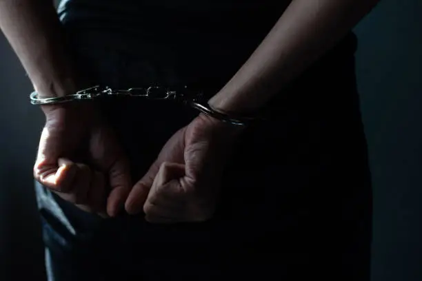 Photo of prisoner concept, Handcuffed hands of a prisoner in prison, Male prisoners were severely strained in the dark prison, violence,