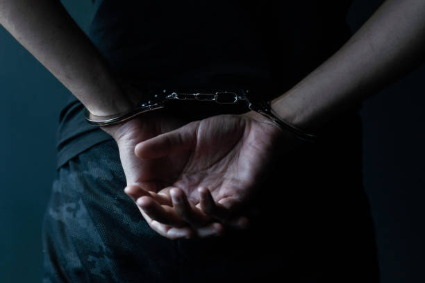 istock male hands in handcuffs black background 1448311416