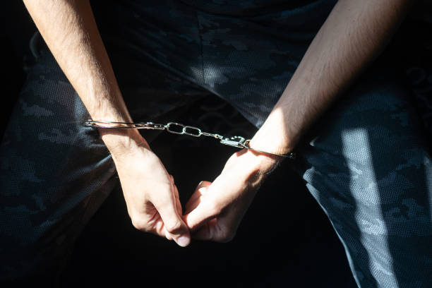 istock male hands in handcuffs black background 1448311424