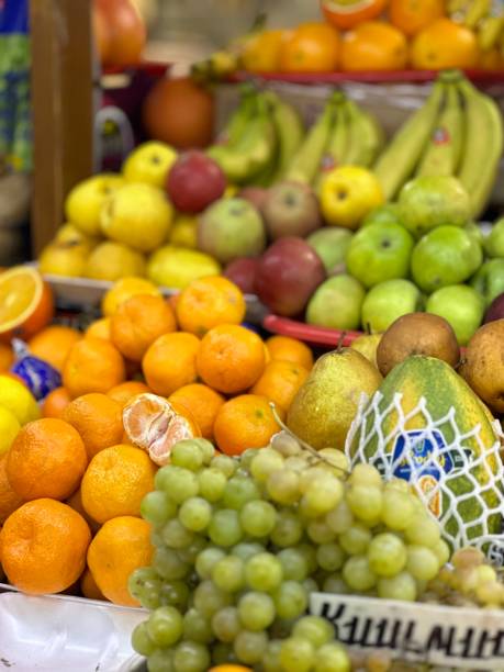 istock fruits at market, tangerines and plums 1448312237