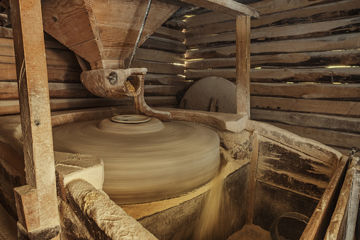 Working old water powered grist mill made of stones and wood