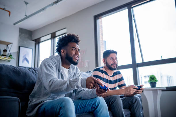 istock Two friends playing video games at home 1448317785