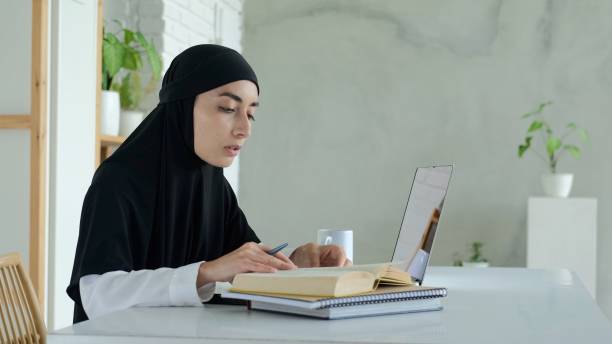 An Arab student studying at an international university uses a laptop remotely via the Internet. Online education abroad for all categories of citizens, regardless of gender and religion. un estudiante árabe que estudia en una universidad internacional utiliza una computadora portátil de forma remota a través de internet. educación en línea en el extranjero para todas las categorías de ciudadanos, independientemente de su género y re