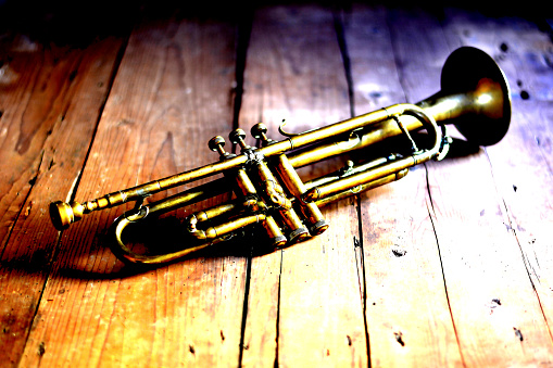 Old and used trombone on white background.