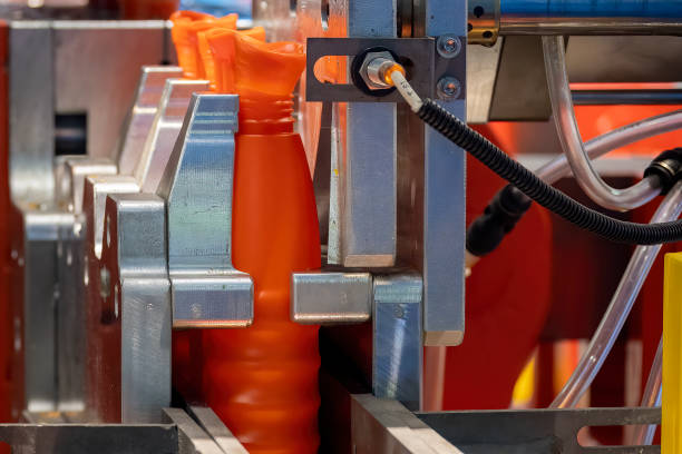 istock The orange bottle container manufacturing process by blow mold machine. 1448319576