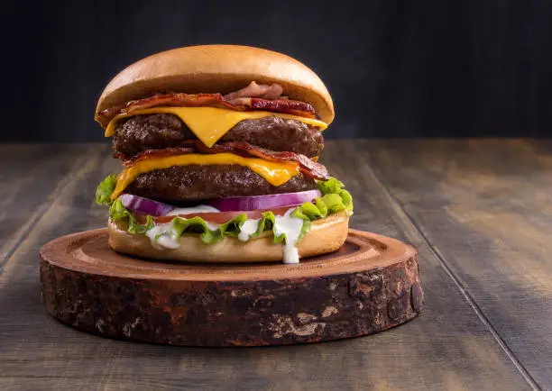 Photo of Fresh tasty burger on wood table.