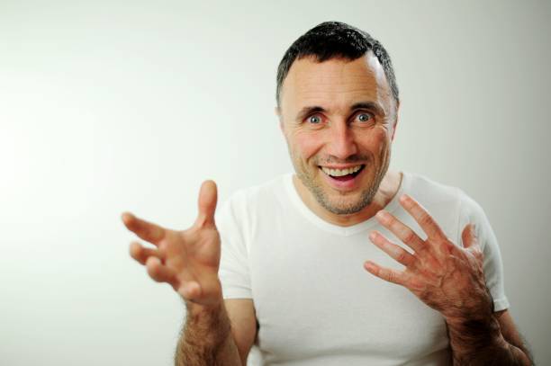 Laughter and amusement on the man face, pleased with himself. Happiness, sincere laughter and joy raised his eyebrows raised his hands Unshaven face black hair with gray hair on head