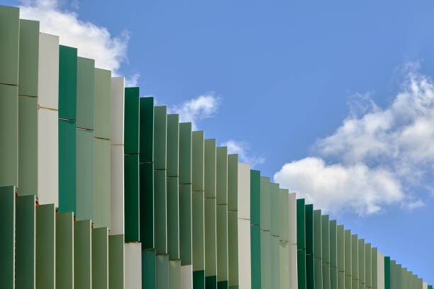 pannelli metallici verticali della facciata di un edificio contro un cielo blu con nuvole bianche - surrounding wall wall color image architecture foto e immagini stock