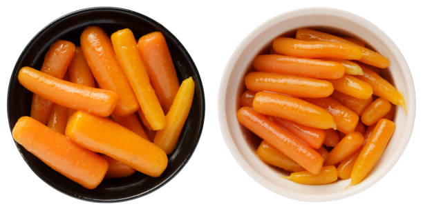 Boiled canned carrots in a bowl isolated on white background stock photo