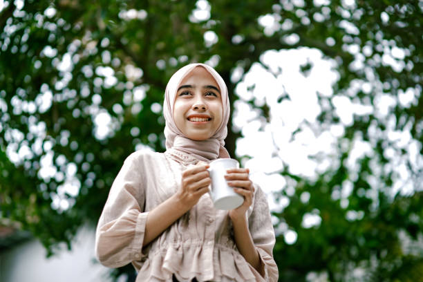 istock Asian woman smiling while holding a mug outdoor. 1448331162