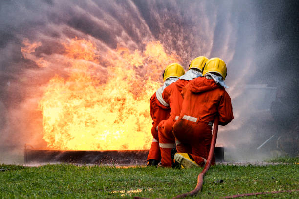 istock Firefighter Concept. Fireman using water and extinguisher to fighting with fire flame. firefighters fighting a fire with a hose and water during a firefighting training exercise 1448331562