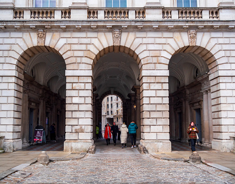 Three arches at the main entrance to the beautiful Somerset House in London’s Strand just before Christmas. Somerset House is a Georgian neoclassical structure surrounding a paved courtyard which is used for many events. Over the years, the buildings have served many functions but today they are used for mainly cultural purposes, including The Courtauld Institute.