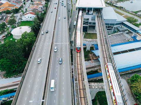 aerial view of elevated highway, mass transit train and car traffic in city