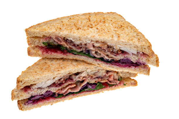 Christmas themed sausage of roast turkey, bacon, stuffing, red cabbage and red currant jelly - white background