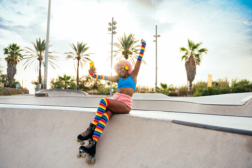 Beautiful woman skating with roller skates and having fun. Professional skater and dancer training in the morning wearing colored and fashionable clothes.