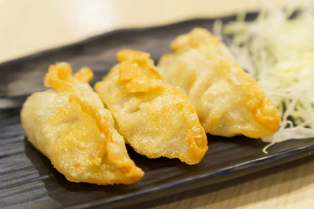 istock golden yellow gyoza placed on black plate with blurred background 1448343927