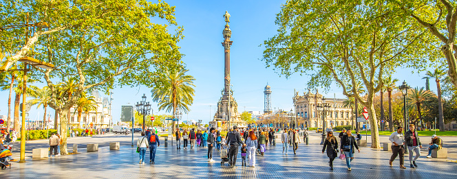 Barcelona, Spain - 14 April, 2022: Panorama of La Rambla pedestrian street, Columbus Monument on a background, popular tourist place in Barcelona city.