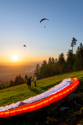 Paraglider at the take-off site at the Devil's mill in the Murg valley in the Black Forest spreads his paraglider against the afternoon sun, Germany