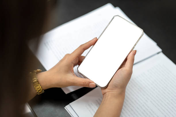 istock Business woman is showing white blank screen on smartphone while checking data and working about new project of business in modern office 1448355305